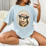 Unhinged Possum DTF Heat Transfer, a humorous graphic t-shirt featuring a happy possum wearing a cap with the word 'UNHINGED' on it.