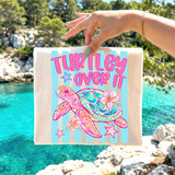 Turtley Over It DTF Heat Transfer, colorful design with a cute turtle, flowers, and stars on a striped background.