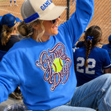 Sequins Softball Red White & Blue Applique Patch, close-up view of a patch with red, white, and blue sequins in a softball design on a blue sweatshirt worn by a woman at a softball game.