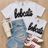 t-shirts featuring oversized fluffy chenille Bobcats mascot patches styled with distressed denim and varsity-inspired school spirit apparel.