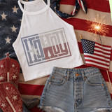 Howdy Spangle Heat Transfer, patriotic summer fashion flat lay with American flag-themed tank top, denim shorts, cowboy boots, small American flag, and sparker against United States flag background.