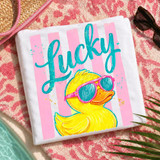 Lucky Duck Stripes DTF Heat Transfer, yellow duck wearing pink sunglasses on a white fabric with pink stripes, set against a summer beach scene.