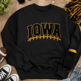 Iowa Football Laces Embroidered Chenille Patch on black sweatshirt, sports team apparel with embroidered lettering and patch design.