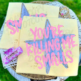 You're Killing Me Smalls Retro Star DTF Heat Transfer, pink text on a yellow fabric with a blue star design.