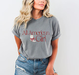 All American Girl Cowgirl Boot DTF Heat Transfer, image of a woman wearing a gray t-shirt with a cowgirl boot graphic and the text 'All American Girl'.
