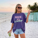 Made To Worship DTF Heat Transfer, printed purple T-shirt with the text 'Made To Worship' being worn by a woman on the beach during sunset.