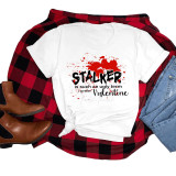 You inspired Stalker Valentine's Sublimation Transfer, a white T-shirt with a red heart and black text, surrounded by red paint splatters, displayed alongside a red and black plaid shirt, blue jeans, and brown boots.