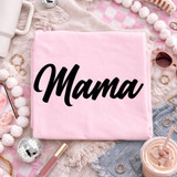 Mama Script BLACK DTF Heat Transfer, pink fabric with black cursive 'Mama' text, surrounded by fashion accessories and decor items.