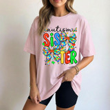 Autism Sister Coquette DTF Heat Transfer, colorful design with bows and puzzle pieces on a pink t-shirt representing autism awareness and sister support.
