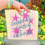 Celebrate Minds Of All Kinds Pink Stripes DTF Heat Transfer, pink stars and blue cursive text on a yellow fabric background.
