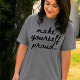 Make Yourself Proud BLACK DTF Heat Transfer, woman wearing a grey t-shirt with black cursive text reading 'make yourself proud' outdoors.