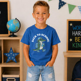 Back To School Gator WHITE DTF Heat Transfer, boy wearing a blue T-shirt with a gator graphic and 'Back to School' text, in a classroom setting.