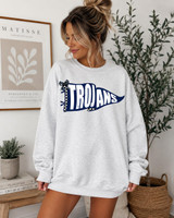 Pennant Teams DTF Heat Transfer, a navy and white graphic design of a sports pennant with the word 'TROJANS' on a light gray sweatshirt worn by a woman in a cozy home setting.