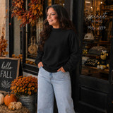Blank Mockneck Sweatshirt — Preorder | Multiple Colors, black mockneck sweatshirt worn by a woman with autumn decorations outside a boutique store.