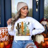 Haunted Desert DTF Heat Transfer, woman wearing a white sweatshirt with a cactus-themed design, fall pumpkins, and Halloween elements.