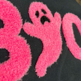 BOO Neon Pink Fluffy Patch, close-up of a soft, textured pink embroidered patch featuring a sad ghost design on a black fabric background.