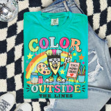 Color Outside The Lines DTF Heat Transfer, colorful and playful graphic design on a teal T-shirt featuring a cheerful character with art supplies, a rainbow, stars, and inspiring words.