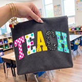 Faux Painted TEACH DTF Heat Transfer, colorful and decorative heat transfer stickers on a dark fabric background.