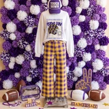 Game Day Polka Dot Helmet DTF Transfers | Football Color Combo Collection, display of a football-themed outfit with a polka dot football helmet graphic on a sweatshirt, purple and yellow plaid pants, and football accessories on a vibrant purple and white flower backdrop.