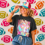 Neon Star Mascot DTF Transfers | School Spirit Mascot Collection, colorful neon star-shaped transfer on a woman's black t-shirt featuring a dog with star-shaped sunglasses, surrounded by a background of football-shaped decorations with smiley faces in vibrant colors.