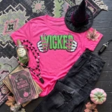 Wicked Halloween sequin apparel patch with green lettering and pink skeleton hands displayed on neon pink T-shirt