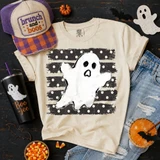 Distressed ghost DTF transfer with black and cream polka dot striped background on a tan Halloween t-shirt