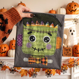Cute Frankenstein DTF Transfer | Patchwork Halloween Monster Design, embroidered Halloween themed patch featuring a cute Frankenstein's monster with large eyes, green face, purple cheeks, and a plaid bowtie.