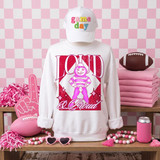 Loud & Proud Mascot DTF Transfers | Retro School Spirit Mascot Collection, white sweatshirt with pink and purple mascot graphic and text, set against a pink-themed background with pom-poms, sunglasses, foam finger, football, and drink container.