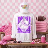 Loud & Proud Mascot DTF Transfers | Retro School Spirit Mascot Collection, featuring a white sweatshirt with a purple cartoon mascot, a white cap with colorful text, and surrounding pink sports-themed accessories in a vibrant setting.