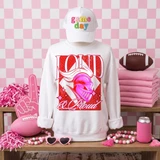 Loud & Proud Mascot DTF Transfers | Retro School Spirit Mascot Collection featuring a white sweatshirt with vibrant red and pink mascot graphic, pink accessories, and a pink checkered background.