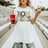 Neutral Marquee Mascot A-P DTF Transfers | School Spirit Mascot Collection, image of a woman holding a Coca-Cola cup, wearing a white shirt with marquee style letters spelling 'Boom Bers' and making a peace sign.
