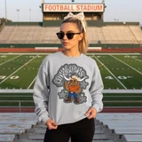 Dotted Mascot DTF Transfers | School Spirit Mascot Collection, a cheerleader wearing a gray sweatshirt featuring a cartoon mascot with cowboy hat and stars, standing on a football field.
