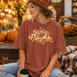 Hey There Pumpkin DTF Transfer, image of a woman wearing a pumpkin-themed T-shirt with fall-inspired script design in an autumn outdoor setting.