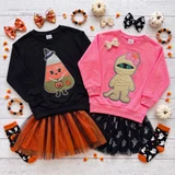 Pink Bow Mummy Youth Chenille Halloween Patch, children’s pink hoodie featuring a mummy with a pink bow and glitter eyes, paired with a black tutu skirt with ghost and pumpkin print, surrounded by Halloween decorations including pumpkins, bows, and candy corn.