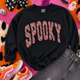 SP00KY appliqué patch transfer with pink, orange and lavender diagonal stripes and black outline pressed on a black sweatshirt