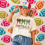 Football Is My Favorite Season DTF Transfer product, a woman wearing a white t-shirt with football bows and text, and a colorful 'Game Day' cap, standing in front of a backdrop decorated with football emojis.