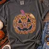 Orange leopard print jack-o’-lantern spangle transfer with black face and bright pink accents shown on a charcoal shirt