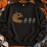 Orange jack-o’-lantern chasing three white ghosts Halloween spangle transfer shown on a black sweatshirt