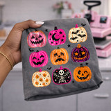 Colorful Halloween pumpkins DTF transfer with nine hand-painted jack-o'-lanterns including a skeleton, candy corn, bats, and starry moon designs in pink, orange, and purple
