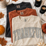 Thankful DTF transfer with bold arched leopard print lettering and black outline on a fall-themed shirt