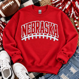 Nebraska red chenille football patch with sparkling sequin border and white puff laces on red sweatshirt