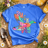 Duck Day DTF transfer with a flying mallard duck and bubble-letter lettering in colorful patchwork fabric pattern style Shown on a Flo Blue t-shirt.