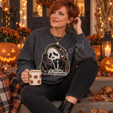 Do you like scary movies ghostface mask DTF transfer in embroidery-style design with hooded cloak, pink hearts, and gold sparkles Shown on a Graphite Heather crewneck sweatshirt.