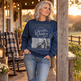 Keith Whitley vintage newspaper-style DTF transfer with The Country Daily masthead, script logo, black-and-white singing photo, and 'Don't Close Your Eyes - When You Say Nothing At All' caption Shown on a Indigo Blue crewneck sweatshirt.