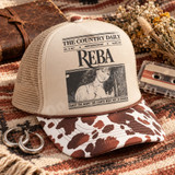 Vintage newspaper-style DTF transfer with REBA masthead, black and white country singer portrait, and 'Fancy - The Night the Lights Went Out in Georgia' headline on a yellow t-shirt Shown on a khaki front panel, brown striped bill, tan mesh back trucker hat.