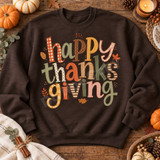 Happy Thanksgiving DTF transfer with colorful patchwork lettering in gingham, plaid, stripes, and polka dot patterns surrounded by fall leaf and berry doodles Shown on a Dark Chocolate crewneck sweatshirt.