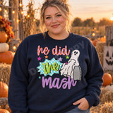 He Did the Mash Halloween DTF transfer with a friendly white ghost emerging from a gravestone, teal polka-dot comic burst, and scattered stars in colorful hand-lettering Shown on a Navy crewneck sweatshirt.