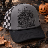 Mysterious & Spooky gothic Victorian mansion DTF transfer with crescent moon, bats, and wrought-iron gate in black ink illustration style Shown on a Charcoal front panel, black bill, black-and-white checkered mesh trucker hat.