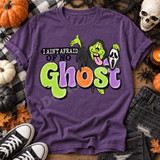 I Ain't Afraid of No Ghost Halloween DTF transfer with cackling witch holding a ghost mask, bats, and bold bubble lettering on a purple shirt Shown on a Grape t-shirt.