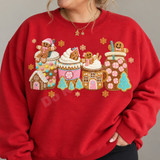 Gingerbread-themed mugs, jars, and cups DTF transfer with whipped cream, gingerbread men, candy, and gold snowflakes in a plush crochet-textured style Shown on a Cherry Red crewneck sweatshirt.
